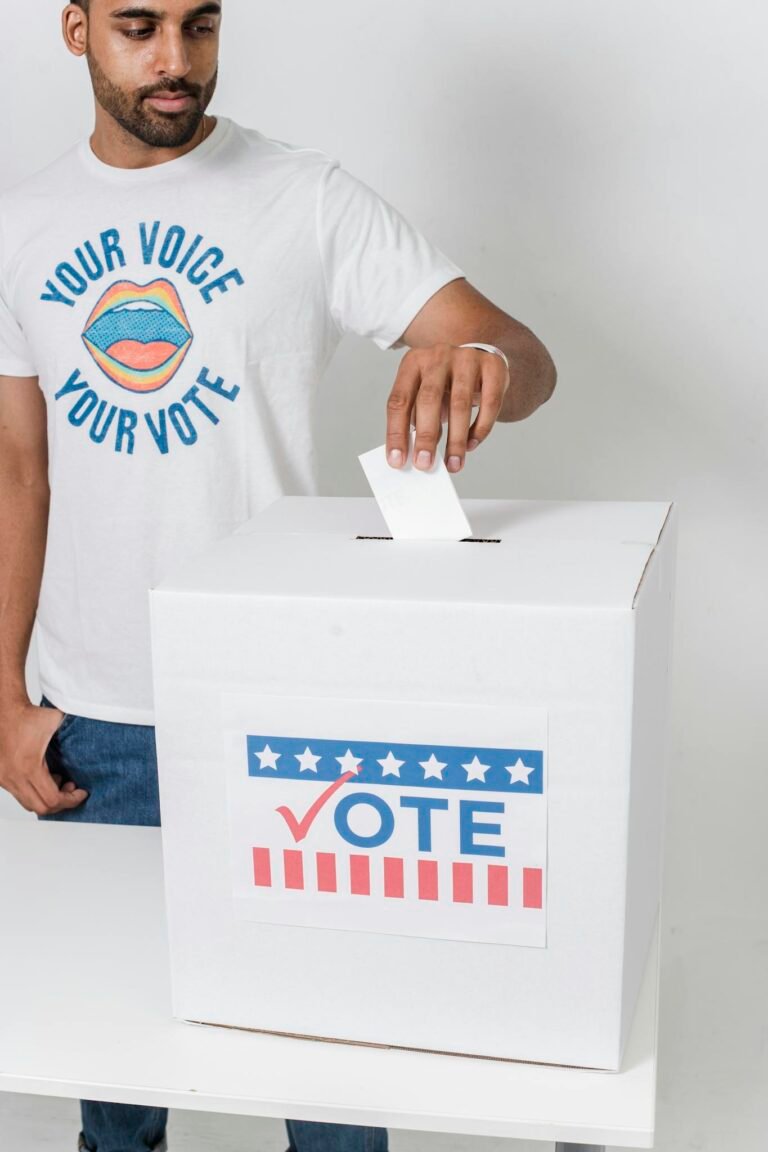 A young man casting his vote at a ballot box, highlighting democratic participation.